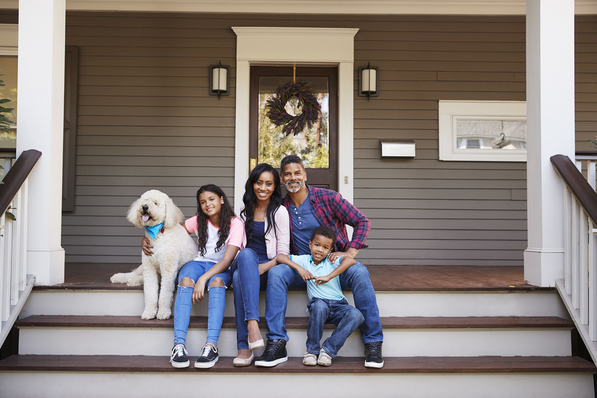 Family takes a portrait together on the front porch of their home