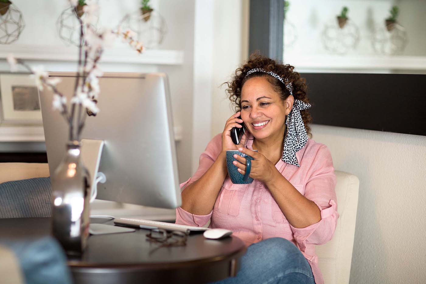 Woman sits relaxed in her home as she talks with a professional on the phone.