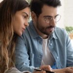 Couple looks at laptop, having a serious discussion
